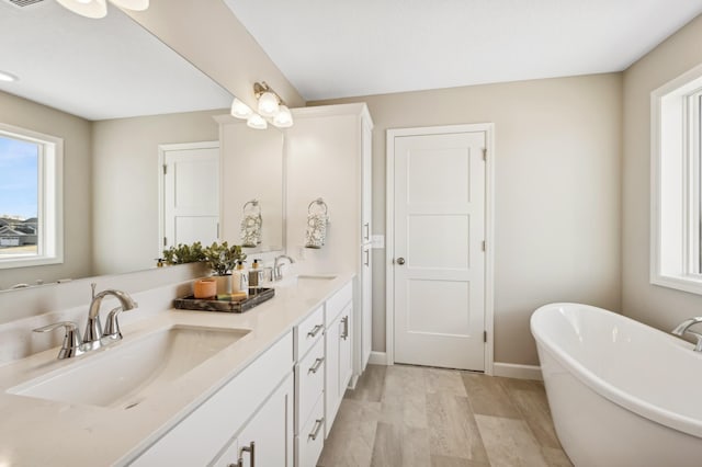 bathroom with vanity, a tub, and wood-type flooring