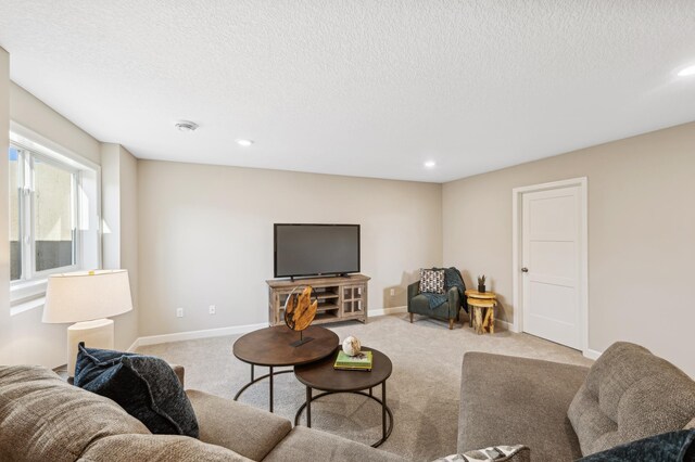 carpeted living room featuring a textured ceiling