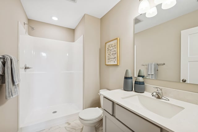 bathroom featuring toilet, a shower, and vanity