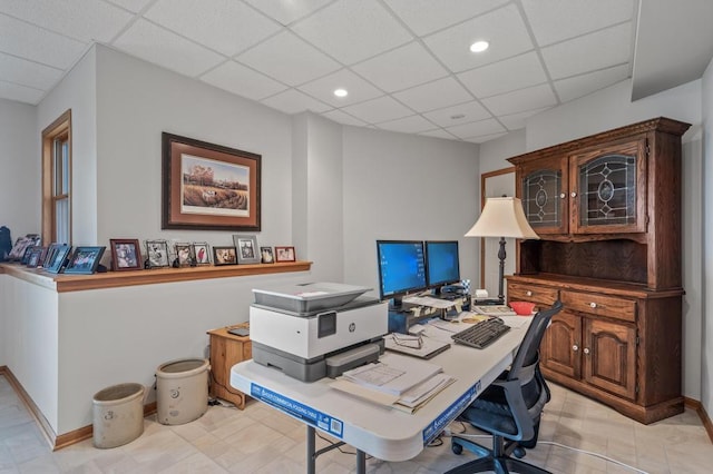 tiled office featuring a paneled ceiling