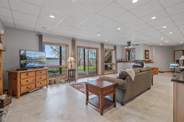 living room featuring a paneled ceiling and ceiling fan