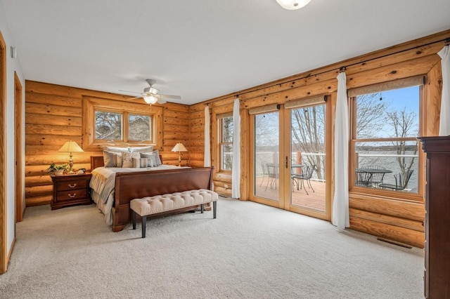 bedroom with ceiling fan, access to exterior, light carpet, and log walls