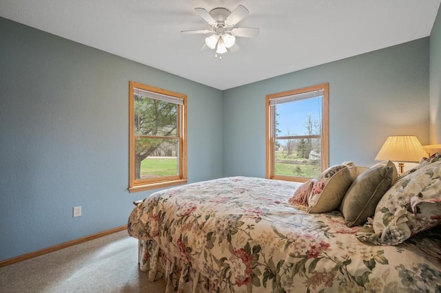 carpeted bedroom with ceiling fan and multiple windows