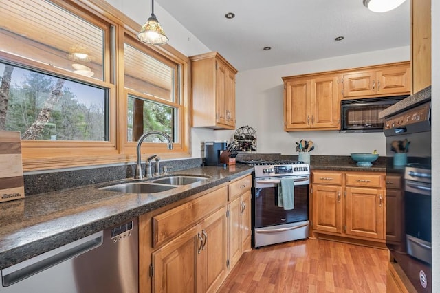 kitchen featuring stainless steel appliances, pendant lighting, light hardwood / wood-style flooring, and sink