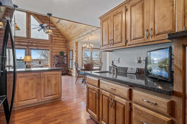 kitchen featuring pendant lighting, sink, light hardwood / wood-style flooring, log walls, and wooden ceiling