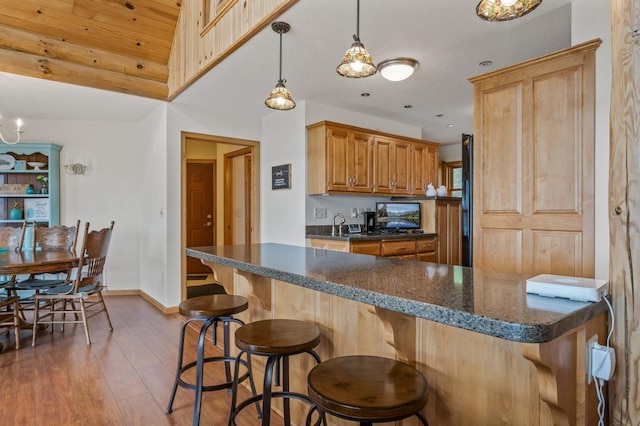 kitchen featuring a breakfast bar, dark wood-type flooring, and pendant lighting