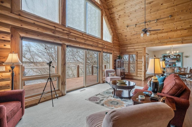 living room featuring high vaulted ceiling, light colored carpet, ceiling fan with notable chandelier, and rustic walls