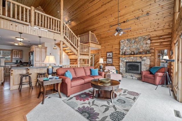 living room featuring wood ceiling, log walls, a fireplace, and high vaulted ceiling