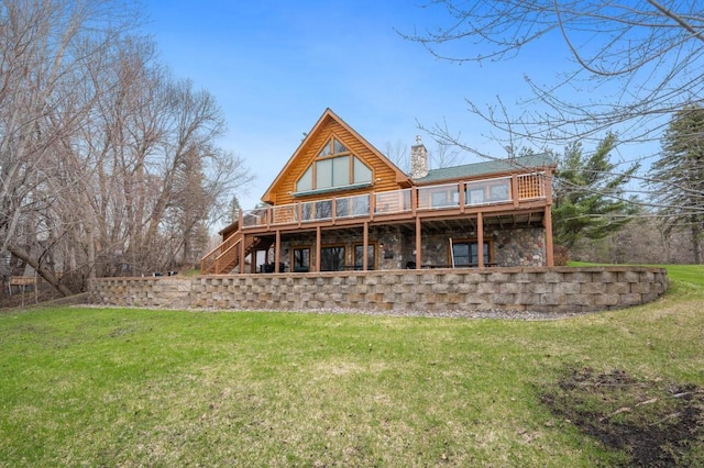 rear view of house with a wooden deck and a lawn