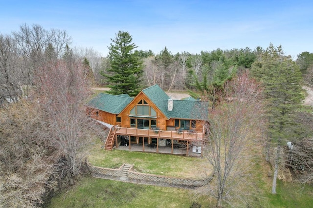 rear view of property with a wooden deck and a lawn