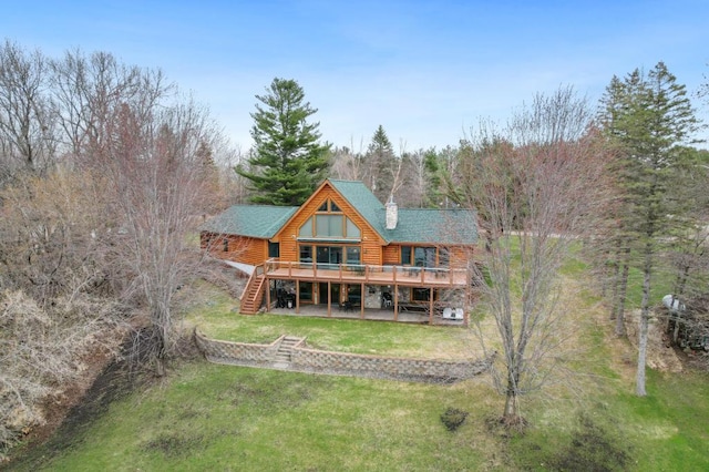 back of property with a wooden deck and a yard