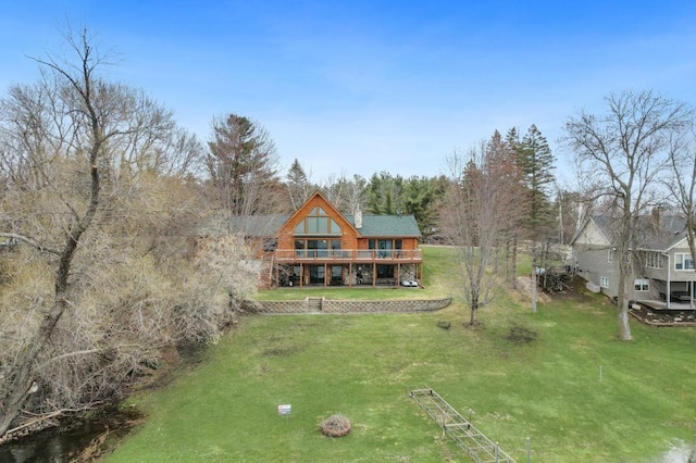 rear view of property featuring a wooden deck and a yard