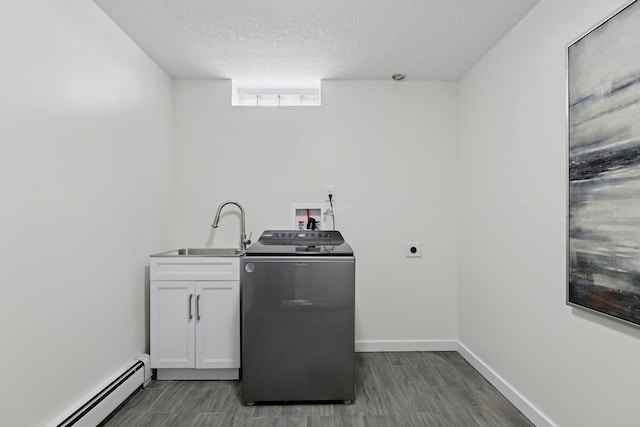 clothes washing area featuring a baseboard heating unit, dark hardwood / wood-style floors, washer / clothes dryer, sink, and cabinets