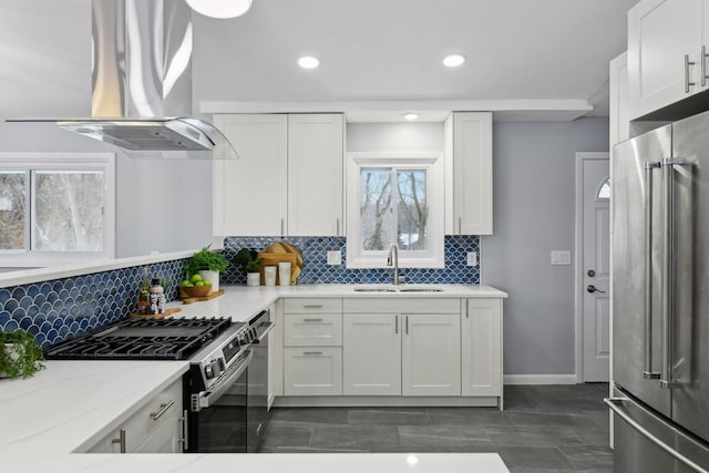 kitchen featuring island exhaust hood, stainless steel appliances, white cabinetry, and sink