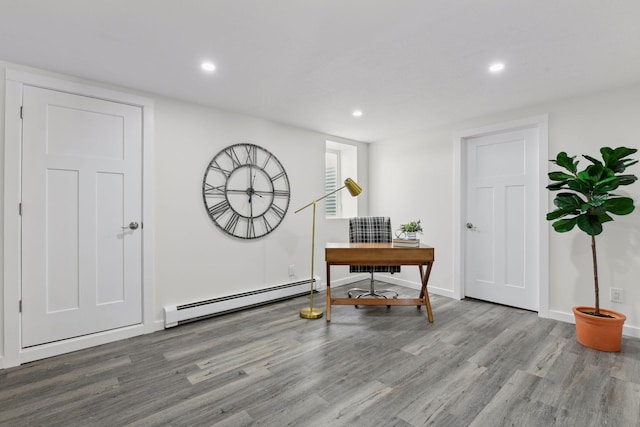 office space featuring a baseboard heating unit and light hardwood / wood-style floors