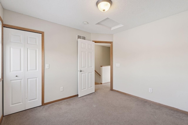 unfurnished bedroom featuring light carpet and a closet