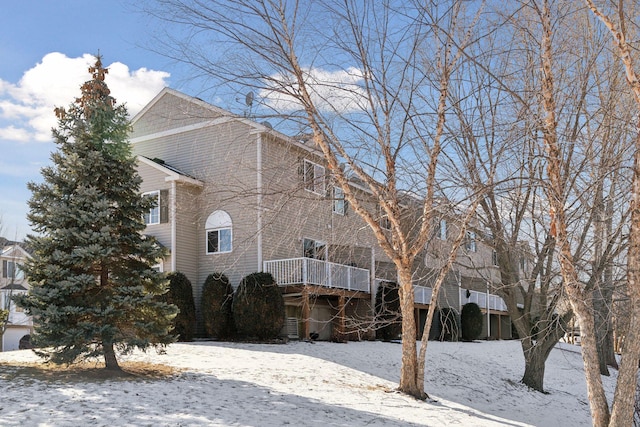 snow covered property with a wooden deck