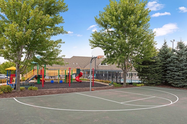 view of basketball court featuring a playground