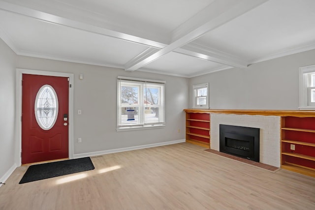 foyer entrance featuring a brick fireplace, beamed ceiling, crown molding, and light hardwood / wood-style flooring