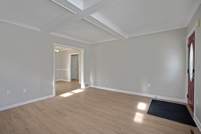 empty room featuring ornamental molding, light hardwood / wood-style flooring, and beam ceiling