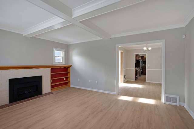 unfurnished living room featuring an inviting chandelier, ornamental molding, a brick fireplace, light hardwood / wood-style flooring, and beam ceiling