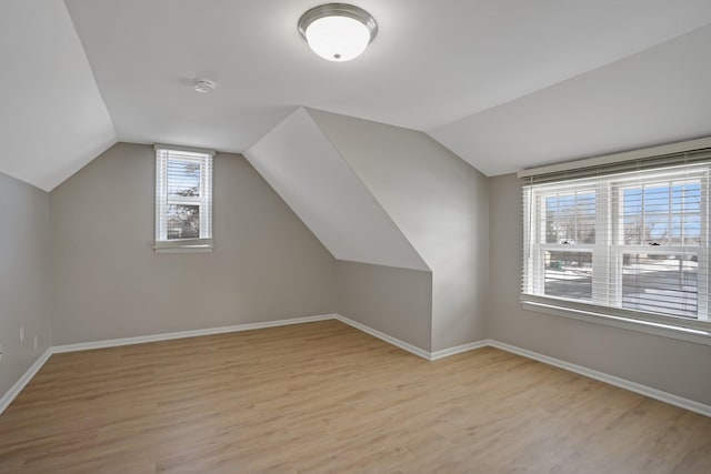 bonus room with vaulted ceiling, plenty of natural light, and light hardwood / wood-style floors