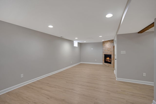 basement featuring light hardwood / wood-style floors and a fireplace