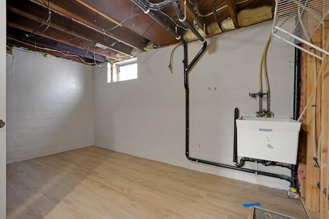 basement featuring sink and hardwood / wood-style floors