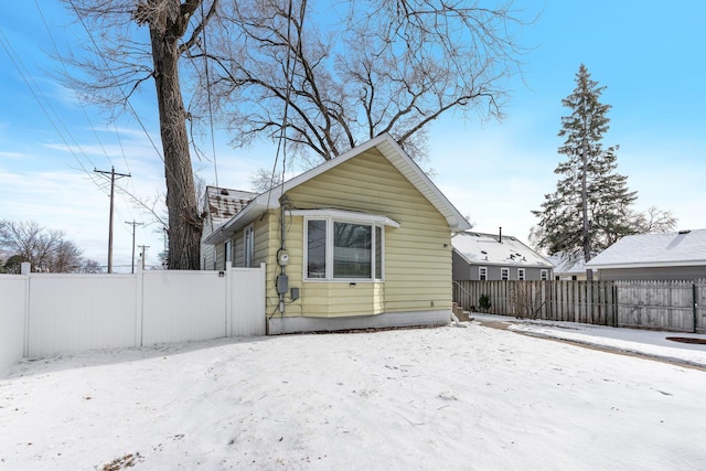 view of snow covered back of property