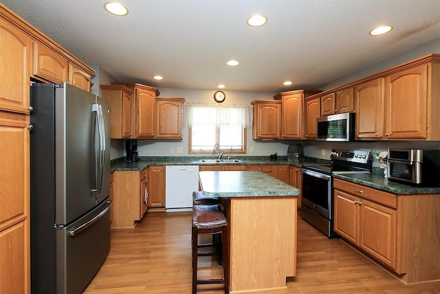 1406 Elsie Dr, Glencoe, MN 55336 - kitchen with appliances with stainless steel finishes, recessed lighting, a kitchen bar, a kitchen island, and light wood-style flooring