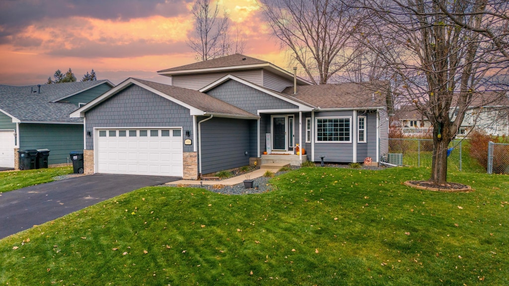 view of front of home with a garage and a yard