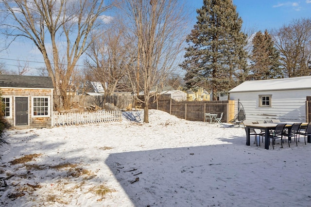 yard layered in snow featuring a storage shed