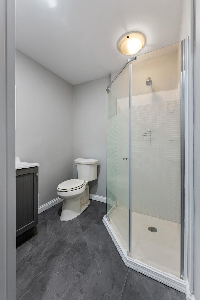 bathroom with walk in shower, vanity, and toilet