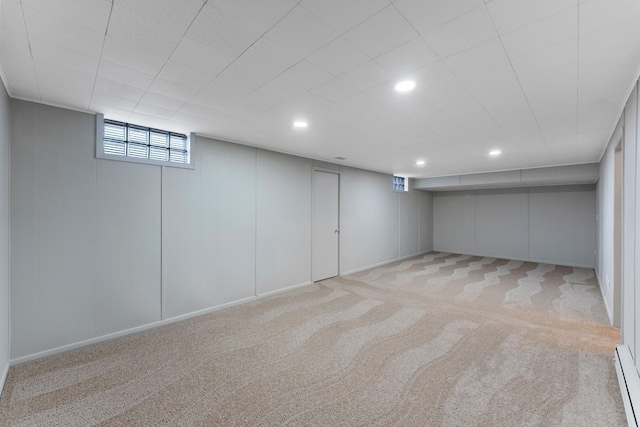 basement featuring a baseboard radiator and light carpet