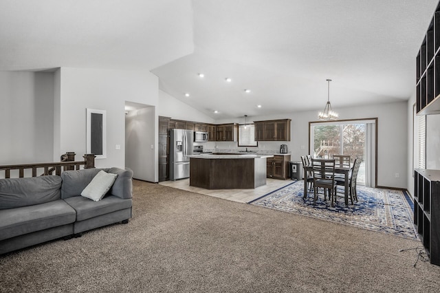 carpeted living room with vaulted ceiling, sink, and a notable chandelier