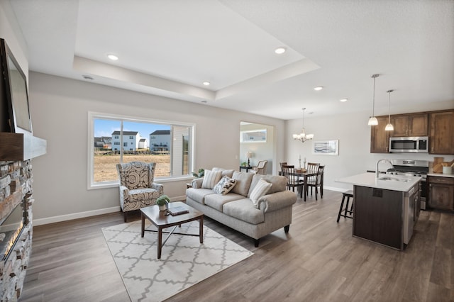 living room with a fireplace, dark hardwood / wood-style floors, and a tray ceiling