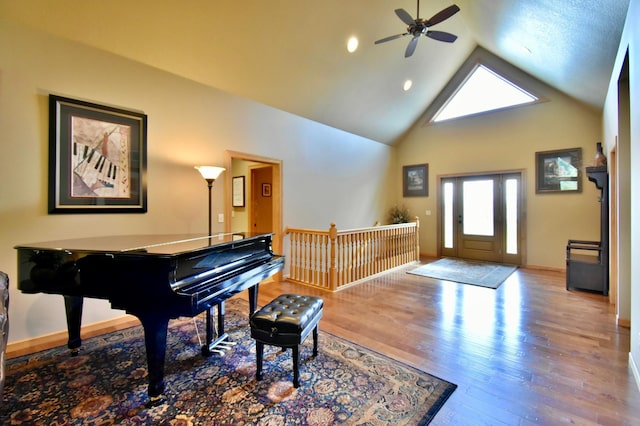 foyer entrance featuring ceiling fan, high vaulted ceiling, and light hardwood / wood-style floors