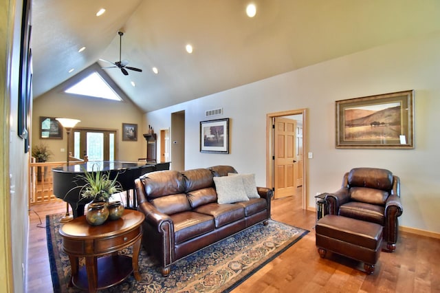 living room featuring hardwood / wood-style flooring, ceiling fan, and high vaulted ceiling