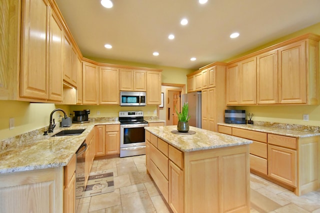 kitchen with sink, appliances with stainless steel finishes, light stone countertops, a kitchen island, and light brown cabinetry