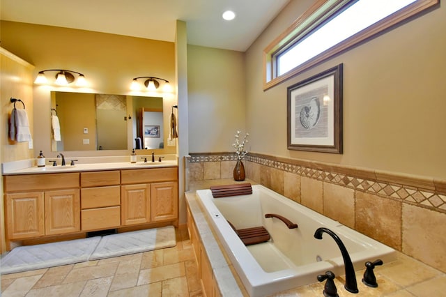 bathroom with vanity and a relaxing tiled tub