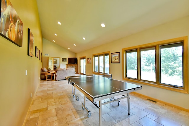 game room with high vaulted ceiling and a fireplace