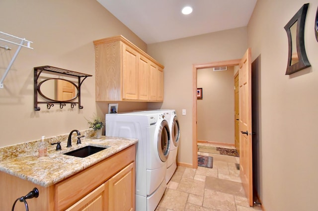 clothes washing area with sink, cabinets, and washing machine and clothes dryer