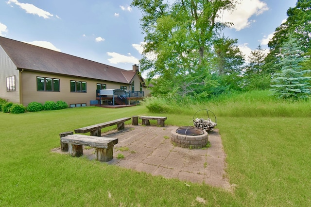 view of yard with a wooden deck, a patio, and an outdoor fire pit