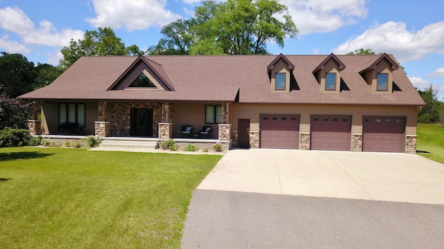 view of front of home featuring a garage, a porch, and a front lawn