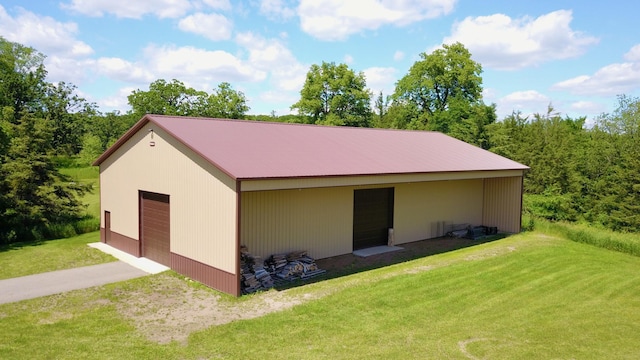 view of side of property with a yard, a garage, and an outdoor structure