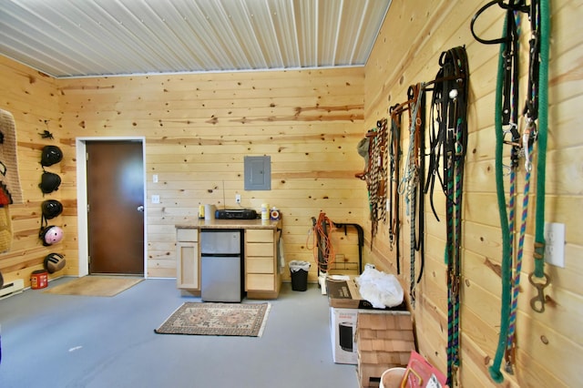 miscellaneous room with electric panel and wood walls