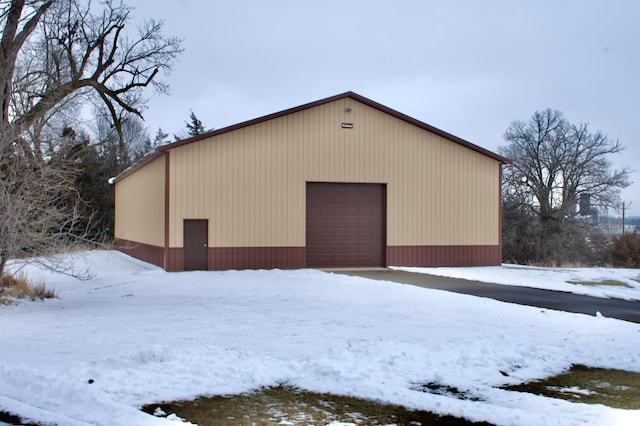 snow covered structure with a garage