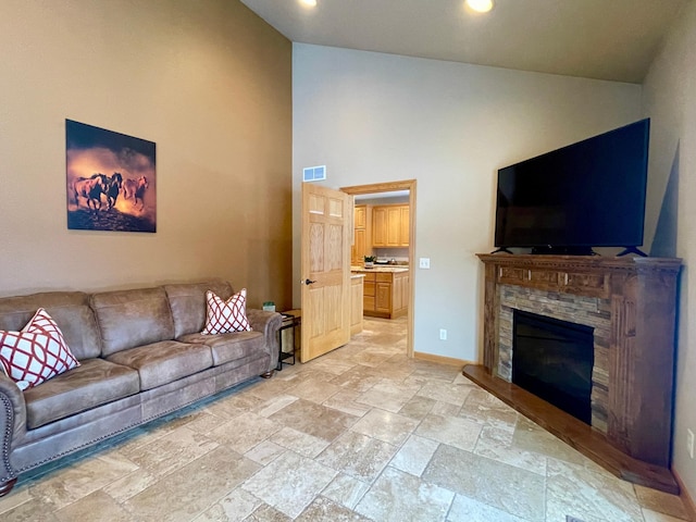 living room with a fireplace and high vaulted ceiling