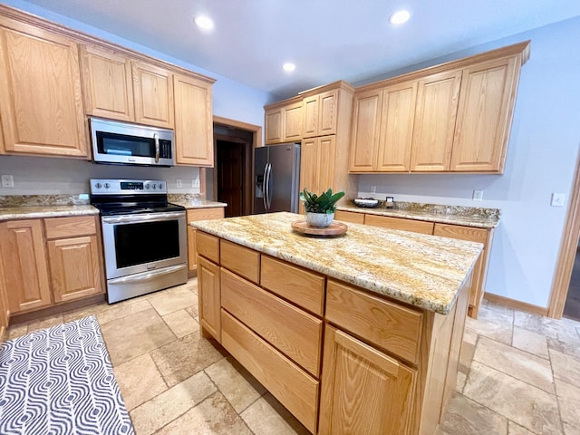 kitchen featuring light brown cabinetry, light stone countertops, a center island, and appliances with stainless steel finishes