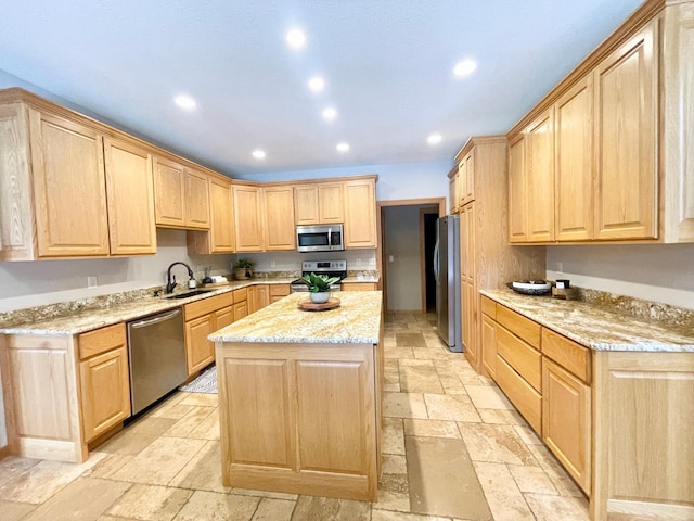 kitchen with stainless steel appliances, sink, light stone counters, and light brown cabinetry